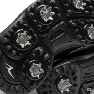 Close-up of the sole of black golf shoes, showcasing the traction-enhancing spikes.