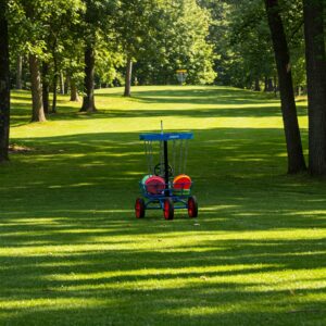 "Disc golf cart easily navigating a slight uphill on a disc golf course."
