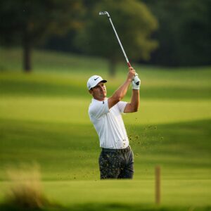 Golfer wearing a comfortable white golf shirt during a backswing.
