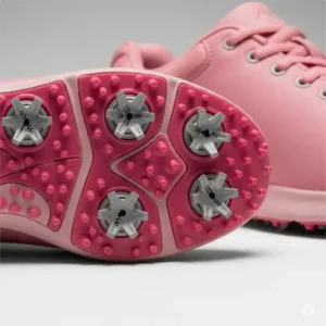 Close-up of pink girls golf shoes featuring innovative soft spikes for superior grip and stability on the green.