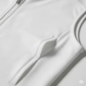 Close-up of a breathable, moisture-wicking fabric on a white womens golf vest, highlighting its innovative material.