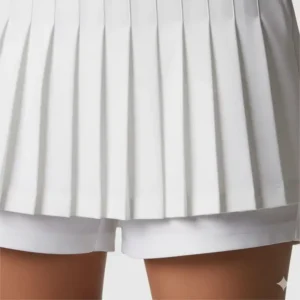 A close-up shot of a white pleated golf skirt showing the detailed pleats and built-in shorts.


