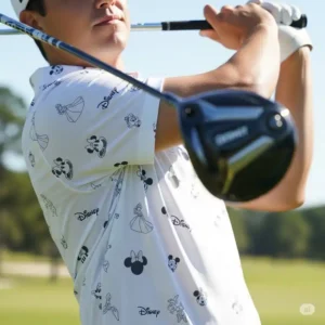 Golfer in motion, wearing a comfortable and flexible Disney golf polo while swinging their club.
